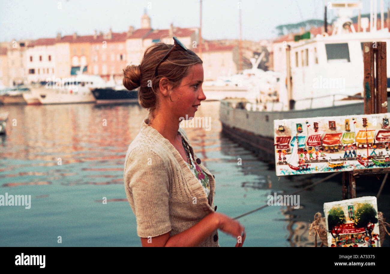 Chica por el lado del muelle con pinturas en venta en St Tropez 1974 Foto de stock