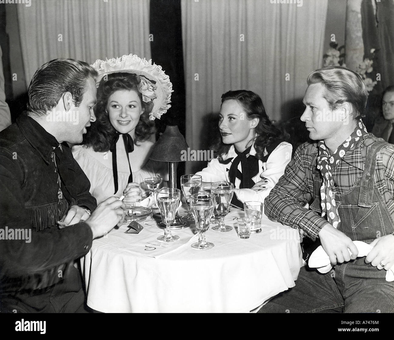 BILL MARSHALL chats con Susan Hayward (HAT) y Jess Barker en 1945. Bill's esposa Michele Morgan presta mucha atención Foto de stock