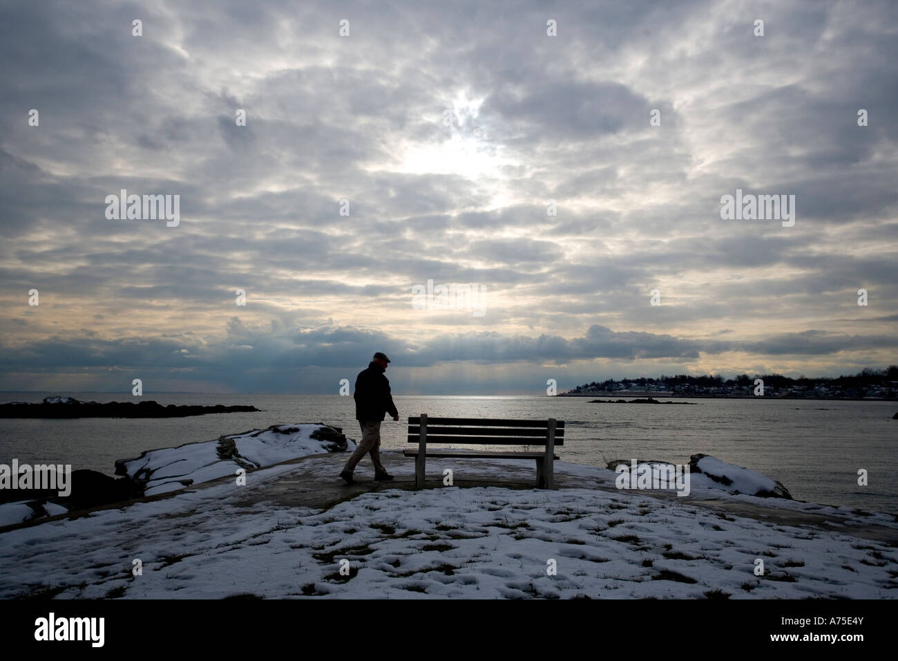 El hombre camina a lo largo de Connecticut Costa con espectacular cielo y nieve del invierno Foto de stock