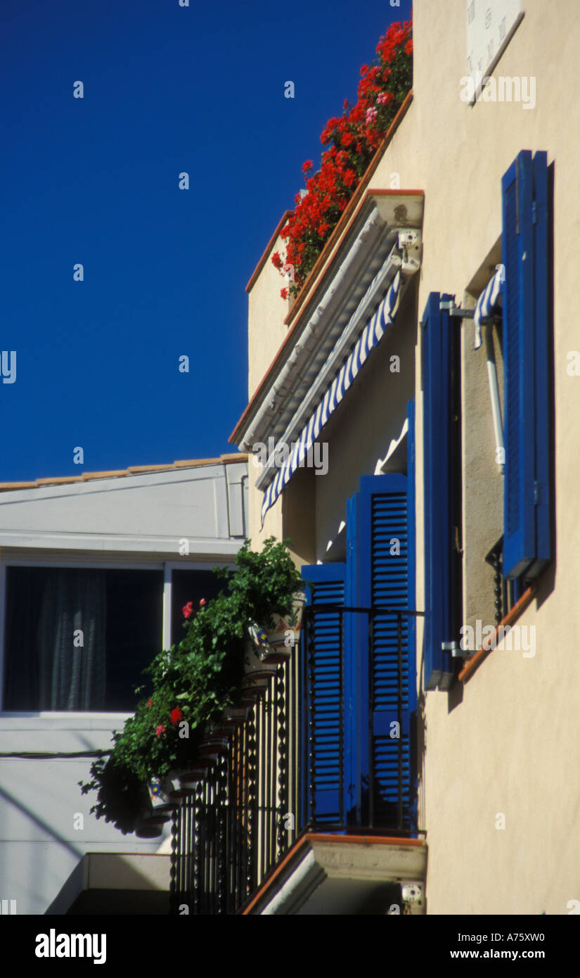 Casa con persianas azules y rojos geranios y cielo azul en Sitges, cerca de  Barcelona Fotografía de stock - Alamy