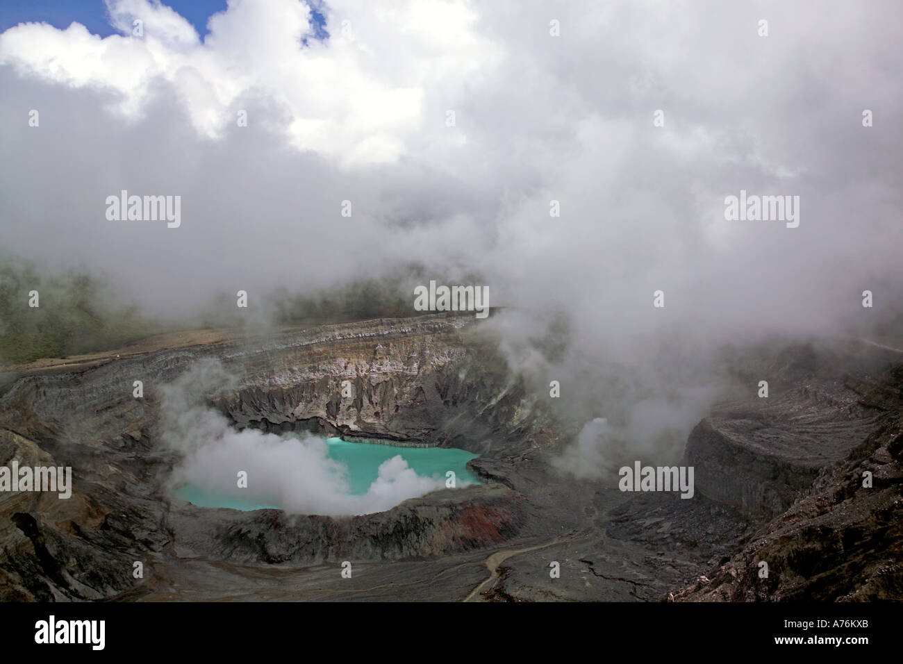 Una vista del Volcán Irazú y verde de Crater Lake en Costa Rica con cúmulos nubosos alrededor del cráter. Foto de stock