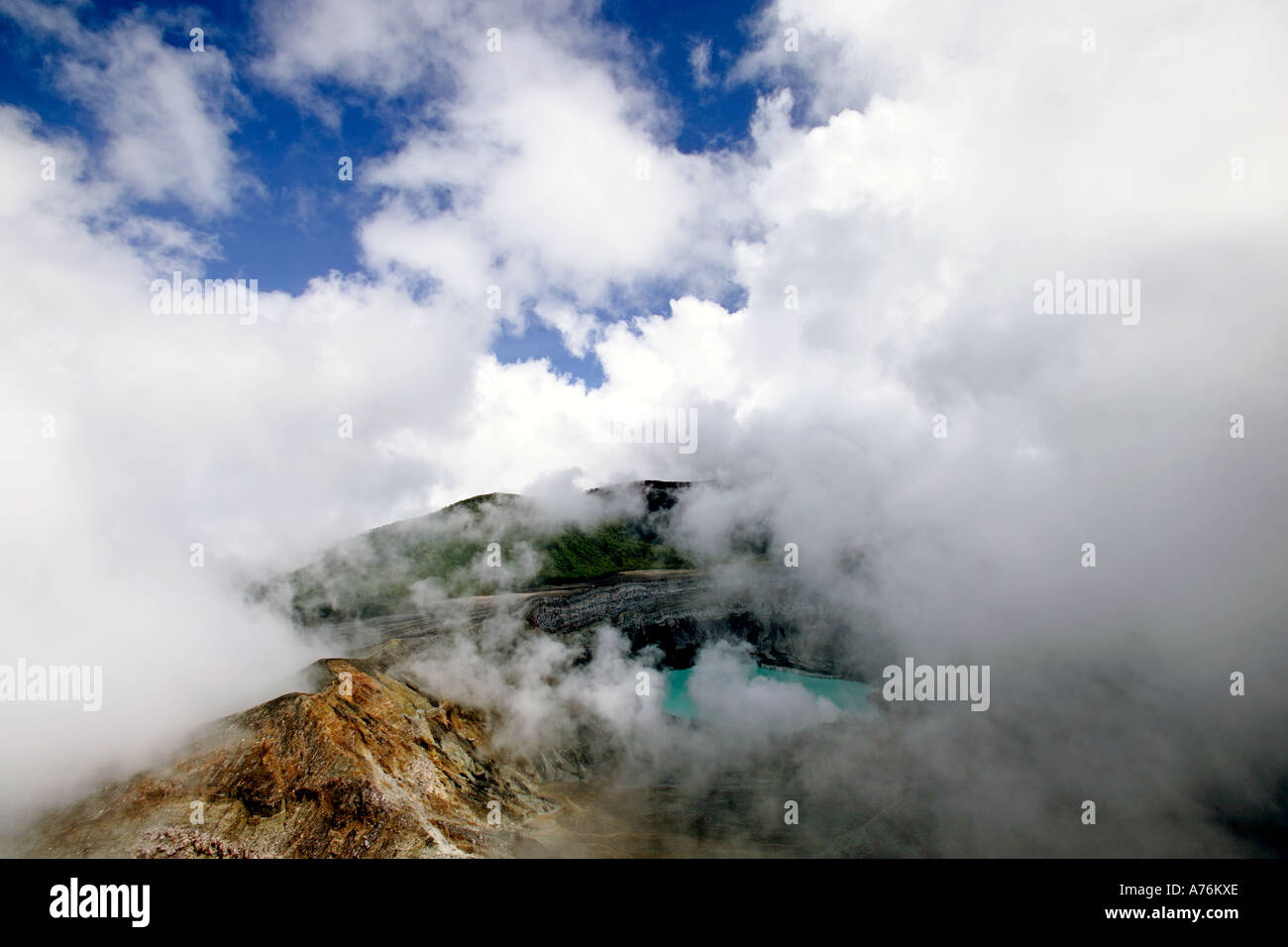 Una vista del Volcán Irazú y verde de Crater Lake en Costa Rica con cúmulos nubosos alrededor del cráter. Foto de stock