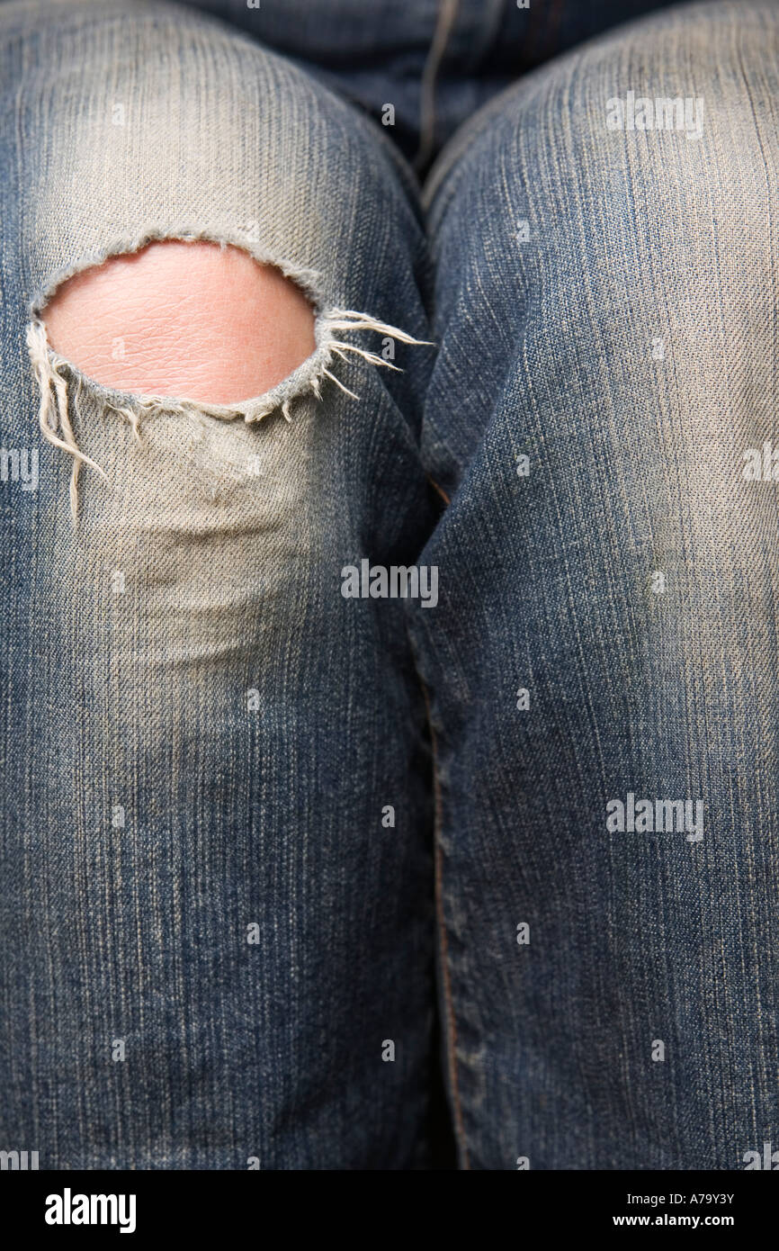Mujer s rodilla mostrando a través de un orificio en pantalones vaqueros  rasgados Fotografía de stock - Alamy