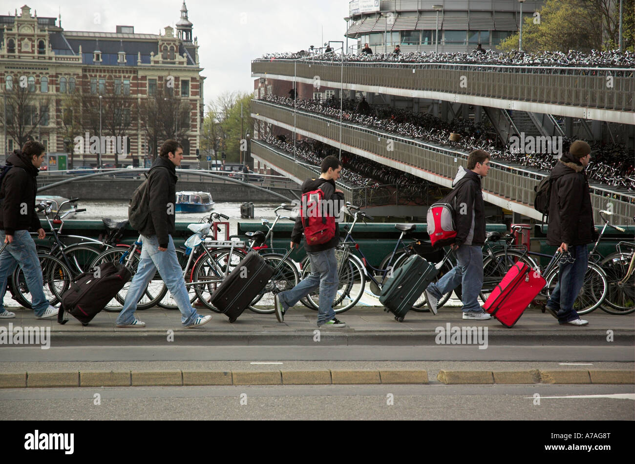 Una línea de turistas en Amsterdam, todos tirando de una maleta de la misma manera Foto de stock