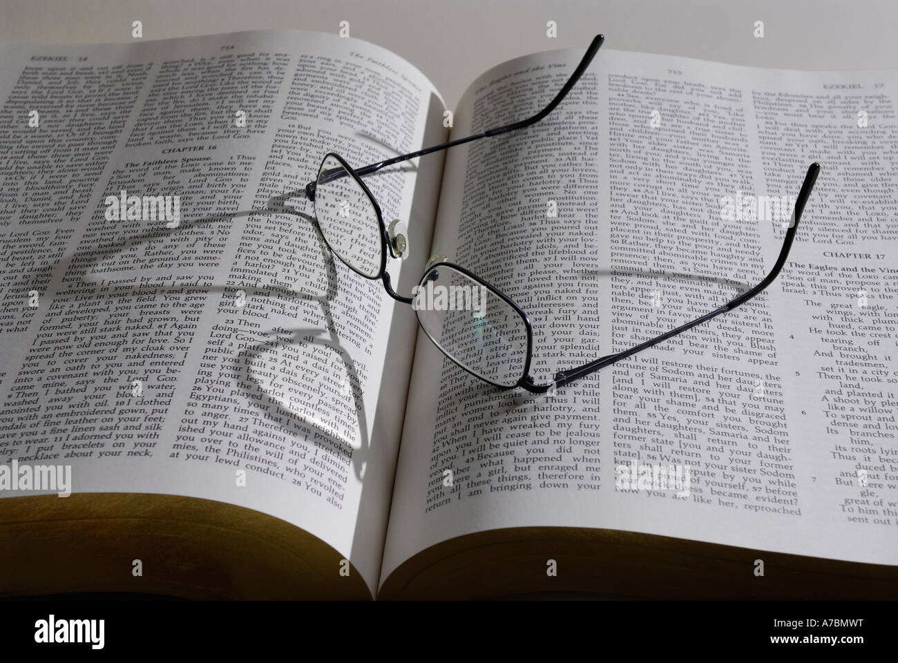 Gafas de lectura con sombra en el gran libro de la Biblia, la palabra de Dios Foto de stock