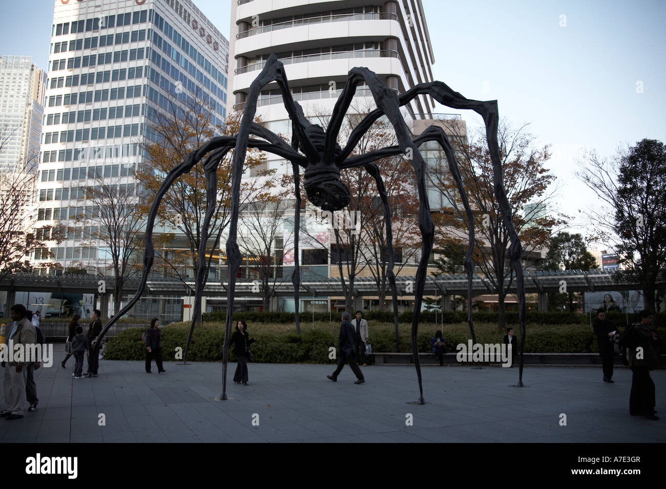 La gente caminando en araña gigante escultura de Louise Bourgeois debajo de Roppongi Hills Mori Tower en la ciudad de Tokio, Japón, Asia Foto de stock