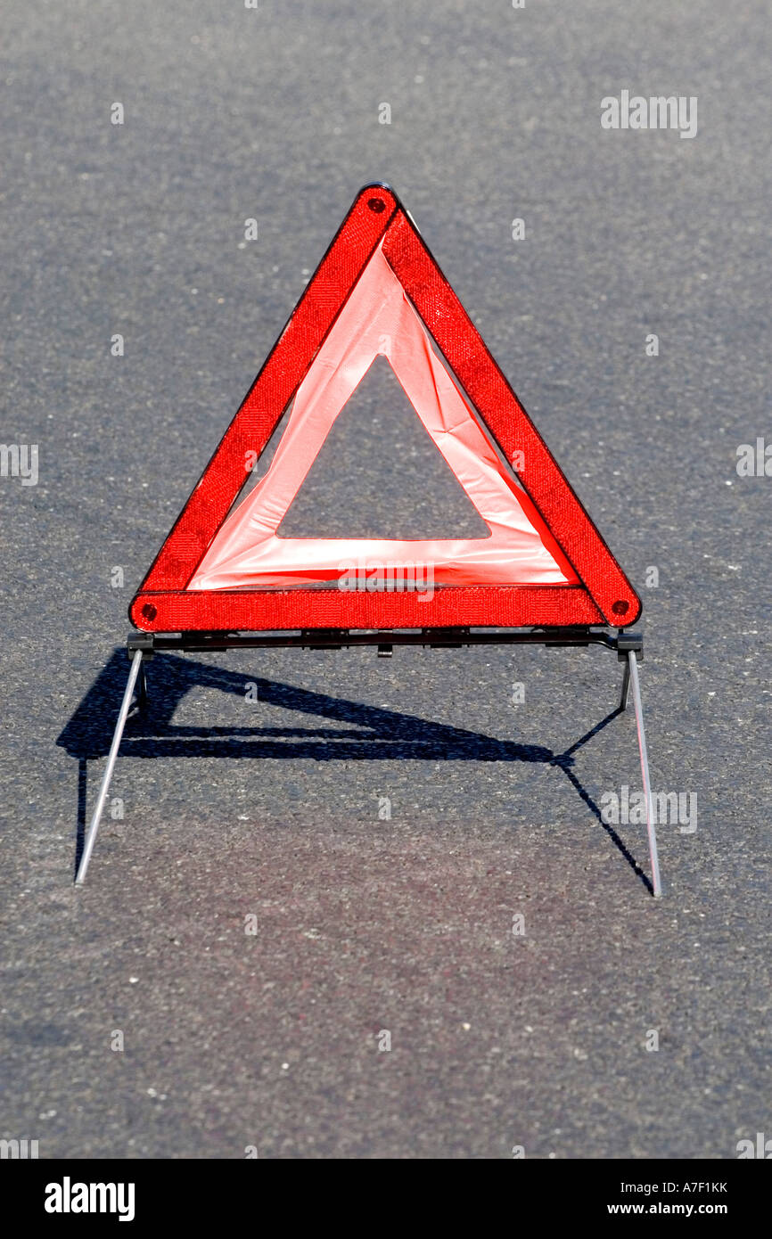 Triángulo de advertencia sobre una carretera Foto de stock