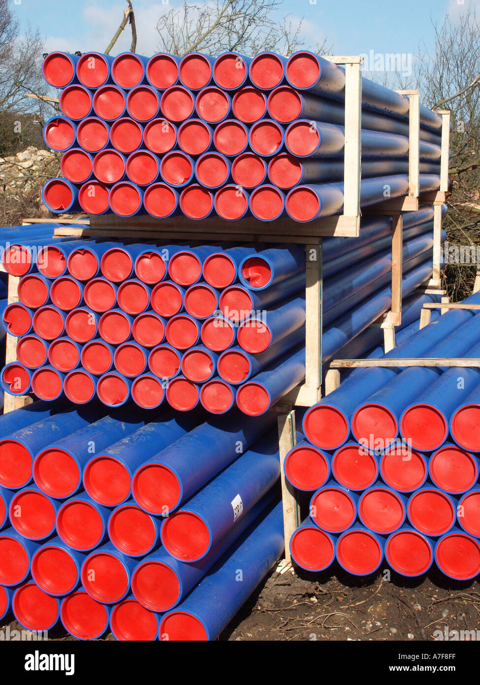 Pilas de tubos de agua de plástico azul equipado con topes finales rojos  espera utilizar en calle trabaja para renovar tuberías enterradas Essex,  Inglaterra Fotografía de stock - Alamy
