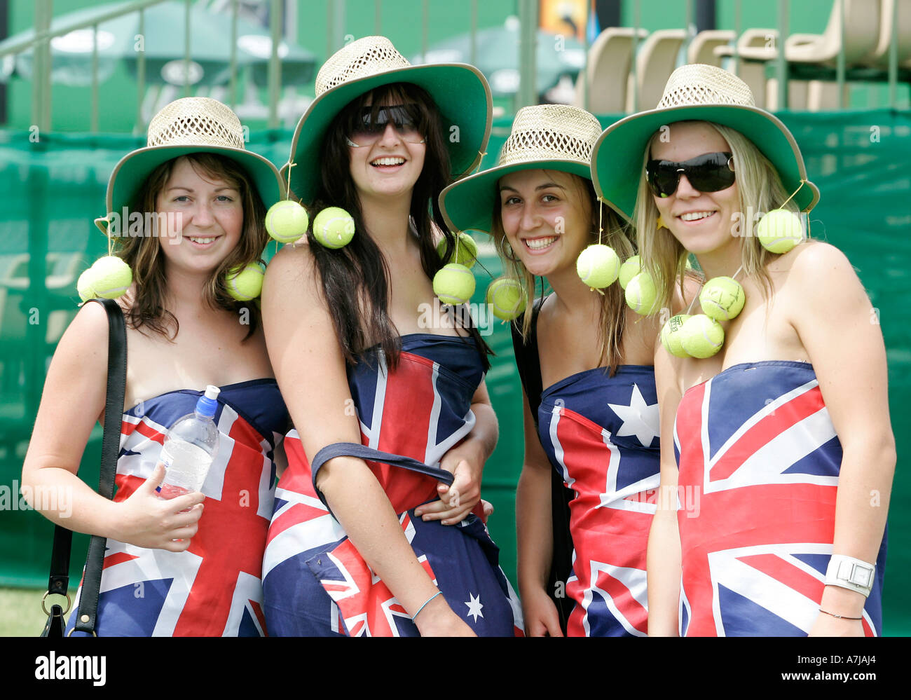 Cuatro jóvenes patrióticos a los aficionados al tenis femenino portando la bandera australiana. Foto de stock