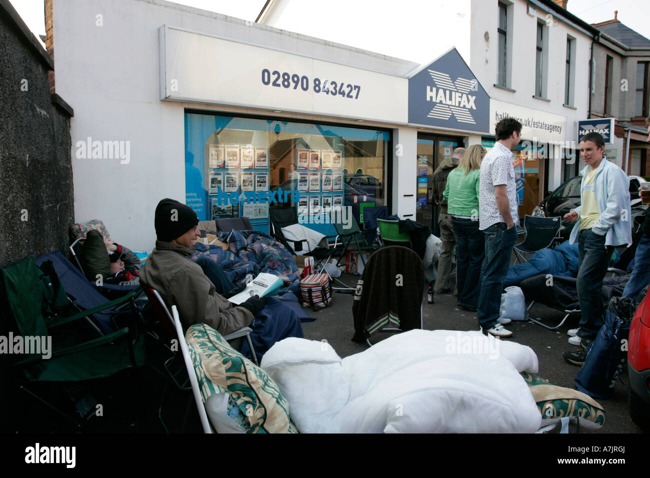 el grupo de compradores de primera vez acampó fuera de una agencia inmobiliaria en irlanda del norte esperando la liberación de nuevos hogares de desarrollo durante el auge inmobiliario en 2007 Foto de stock