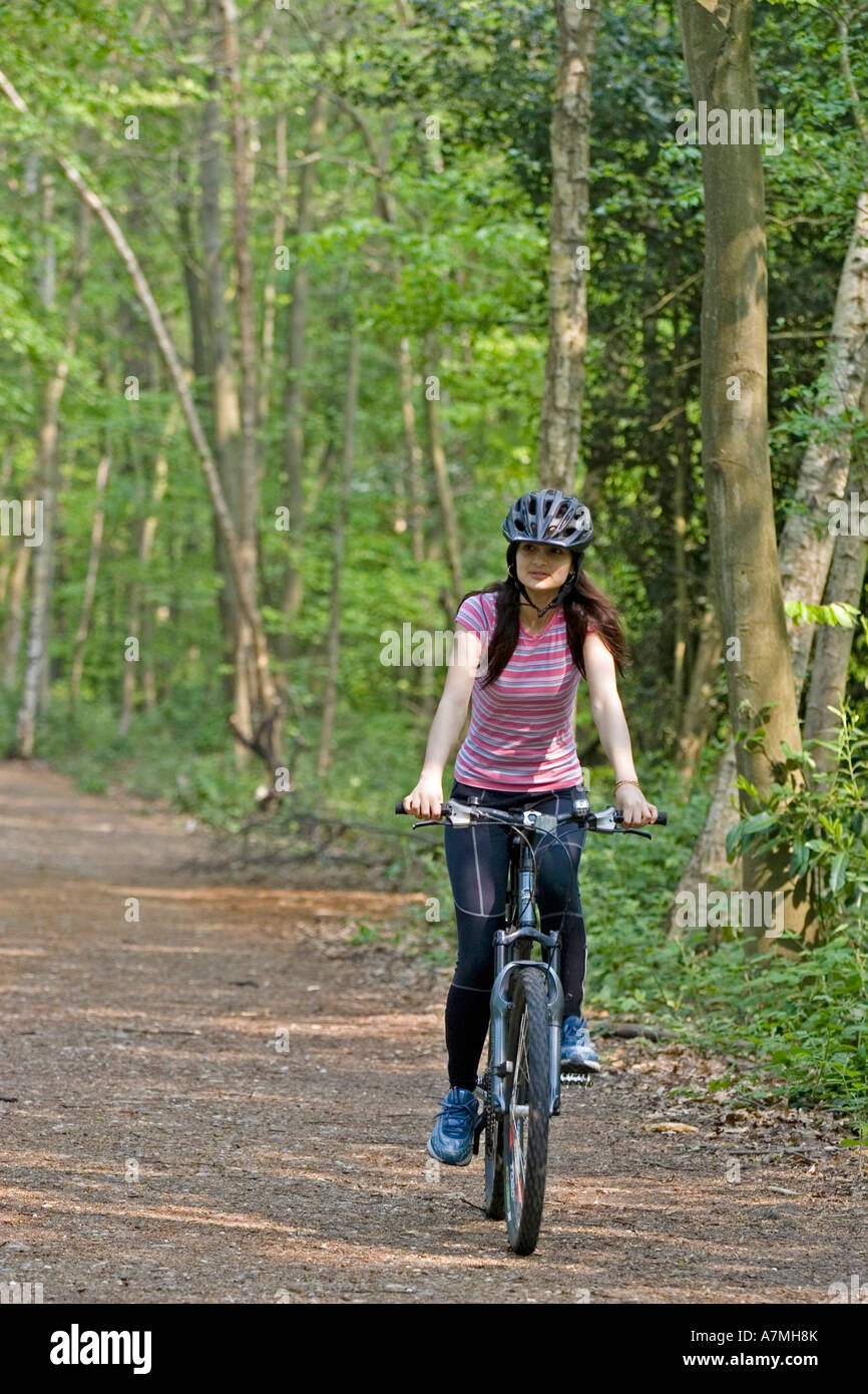 Chica montada en su bicicleta de monta a a lo largo de un camino