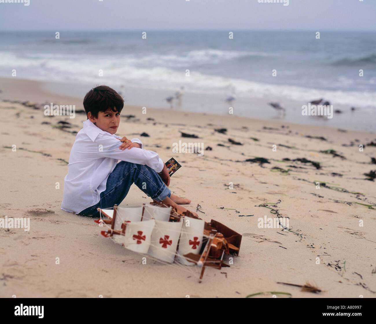 Chico 6, 7, 8, 9, 10, 11, 12 años de edad, sentada en la playa, Southampton, Long Island, en el Estado de Nueva York, EE.UU. Foto de stock