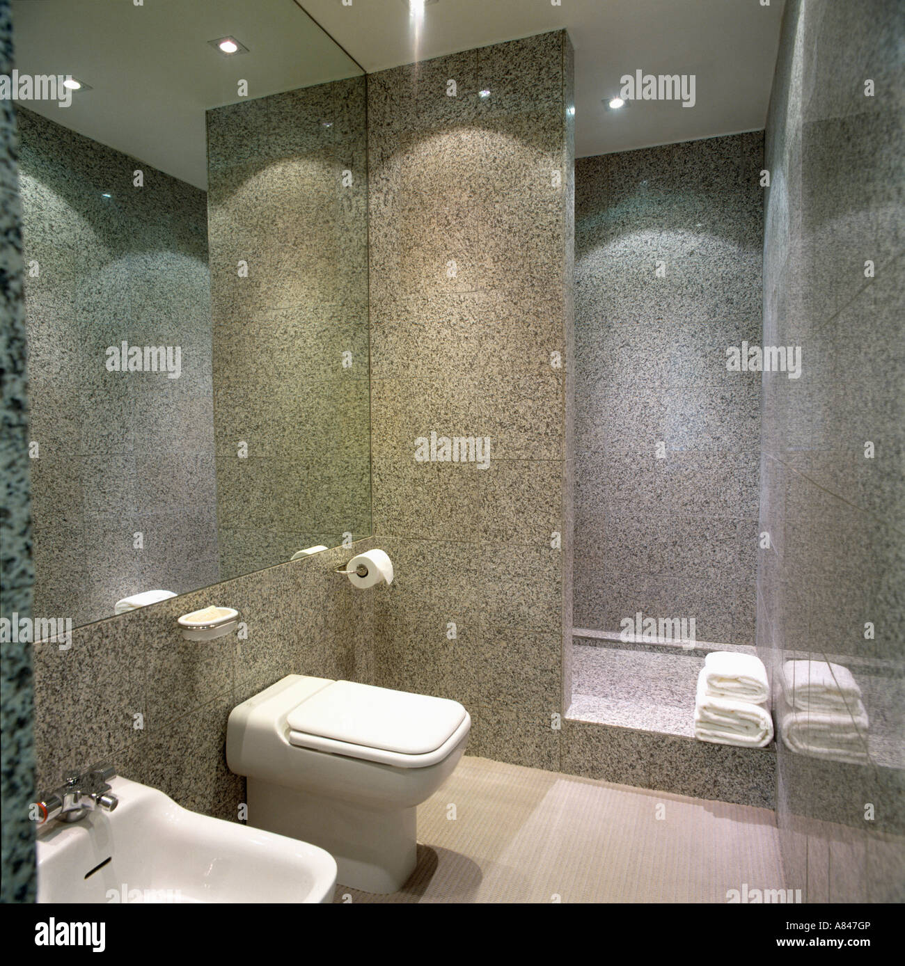 Baño moderno con paredes de granito pulido y espejo grande Fotografía de  stock - Alamy