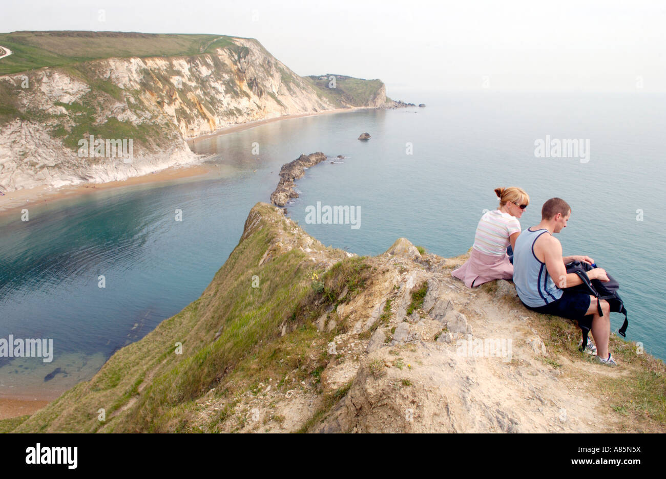 Los turistas miran al mar en San Oswalds Bay y Man o' War en la costa de Dorset al sur de Inglaterra UK Foto de stock