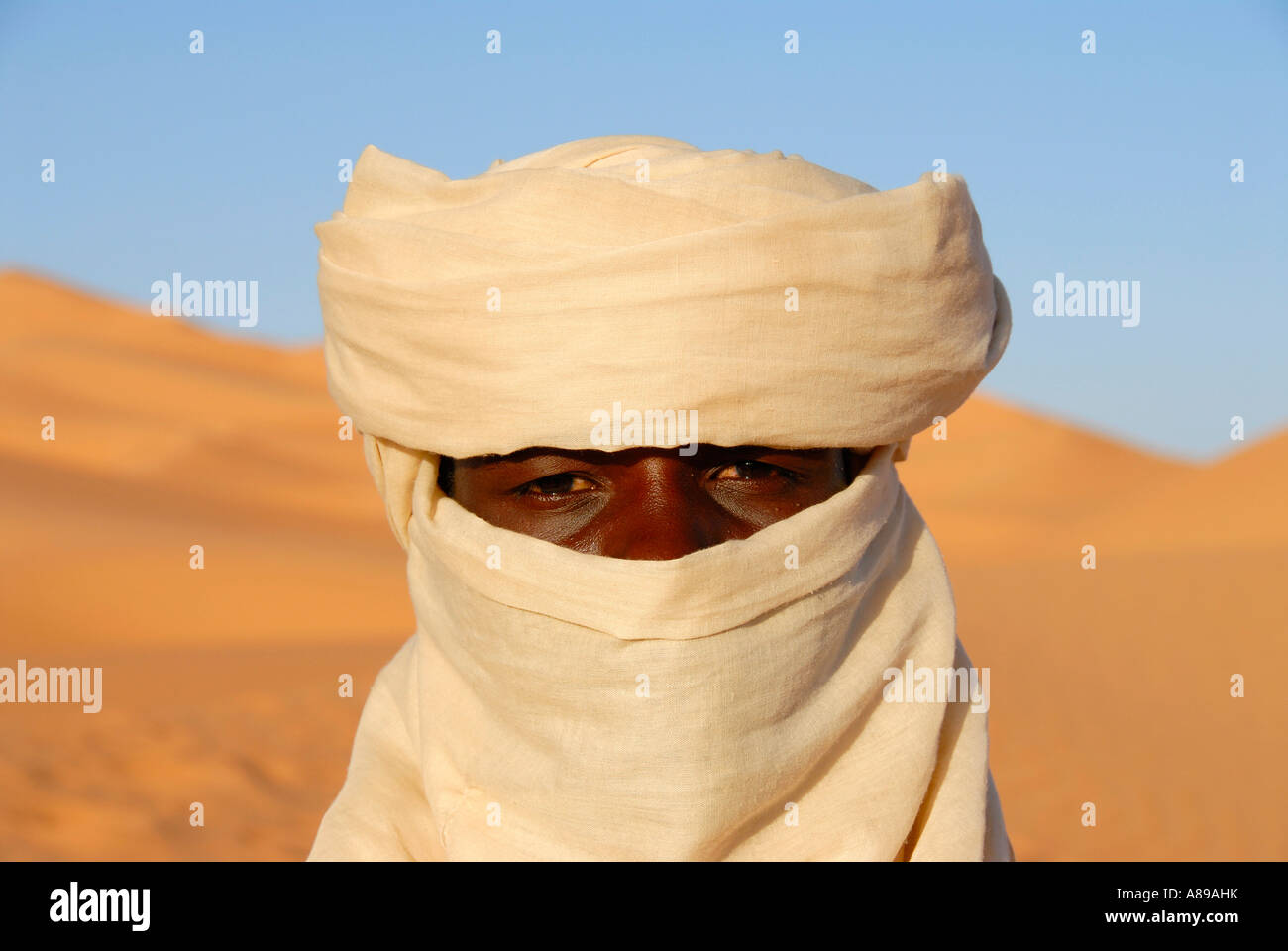 Retrato Tuareg envuelto en un turbante en Libia Mandara sanddunes Foto de stock