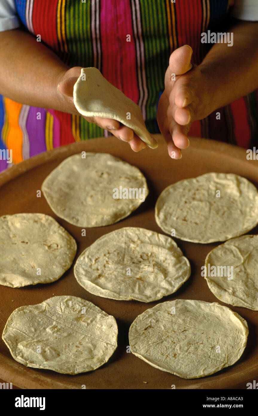 Mujer hace tortillas de maíz a mano y cocineros en un comal de barro grande  Fotografía de stock - Alamy
