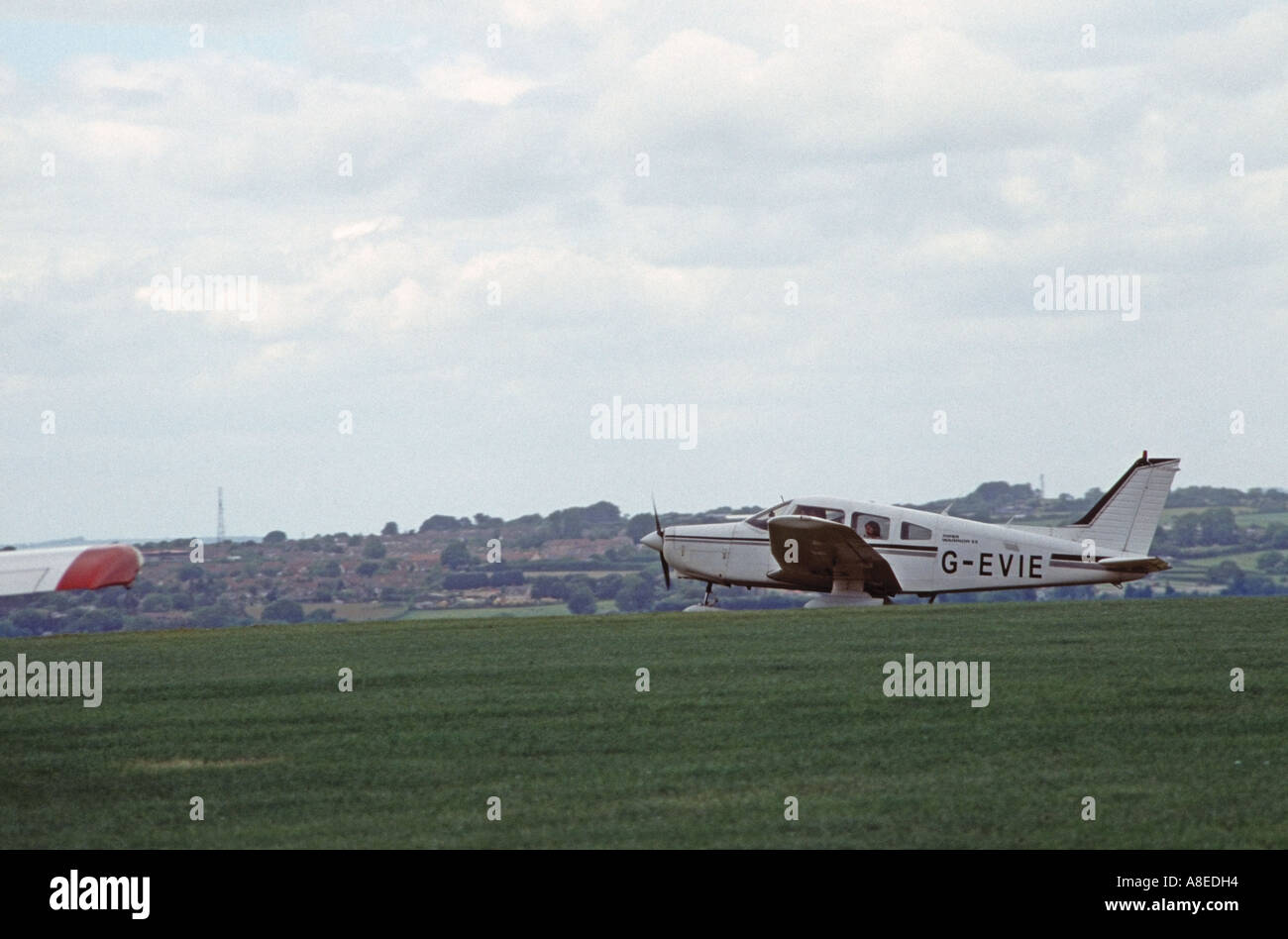 Piper guerrero II despega de Compton Abbas aeródromo, Dorset Foto de stock