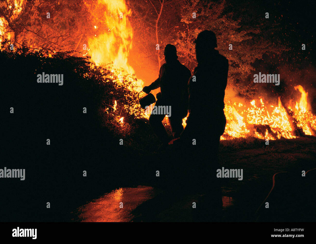 Australia. Silueta de los bomberos que luchan contra un incendio de monte. Foto de stock