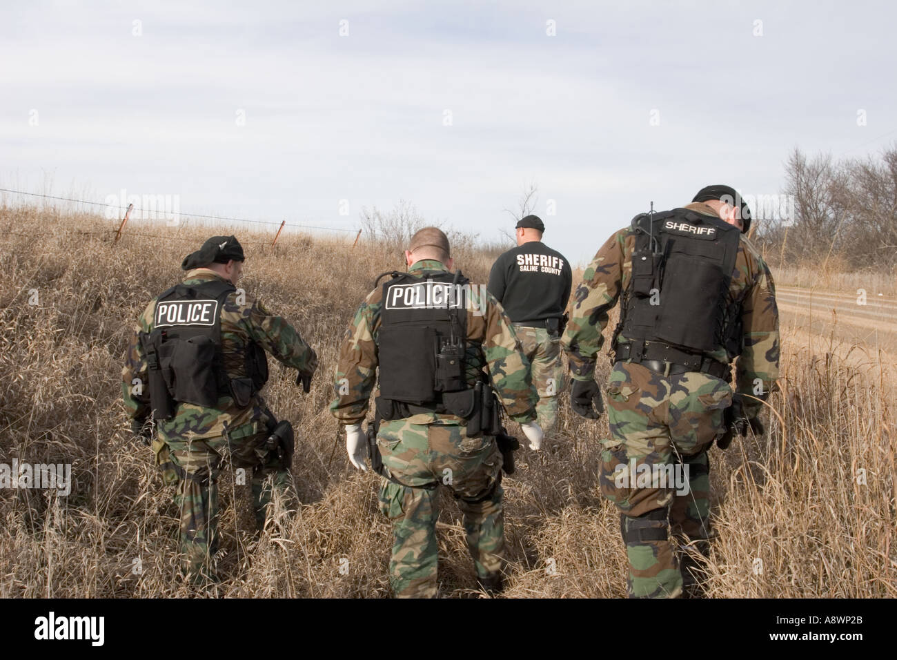 Los sheriffs y adjunto de policía rural buscando en una zanja para una  pistola lanzada por un sospechoso durante una búsqueda. Nebraska, Estados  Unidos Fotografía de stock - Alamy