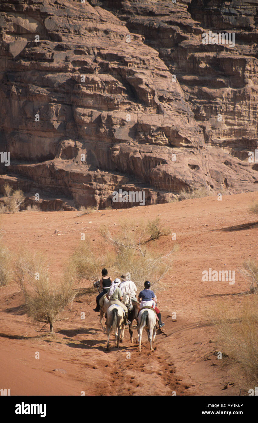 Los jinetes en caballos árabes seguir los pasos de Lawrence de Arabia que cruzan el Wadi Rum, Jordania Foto de stock