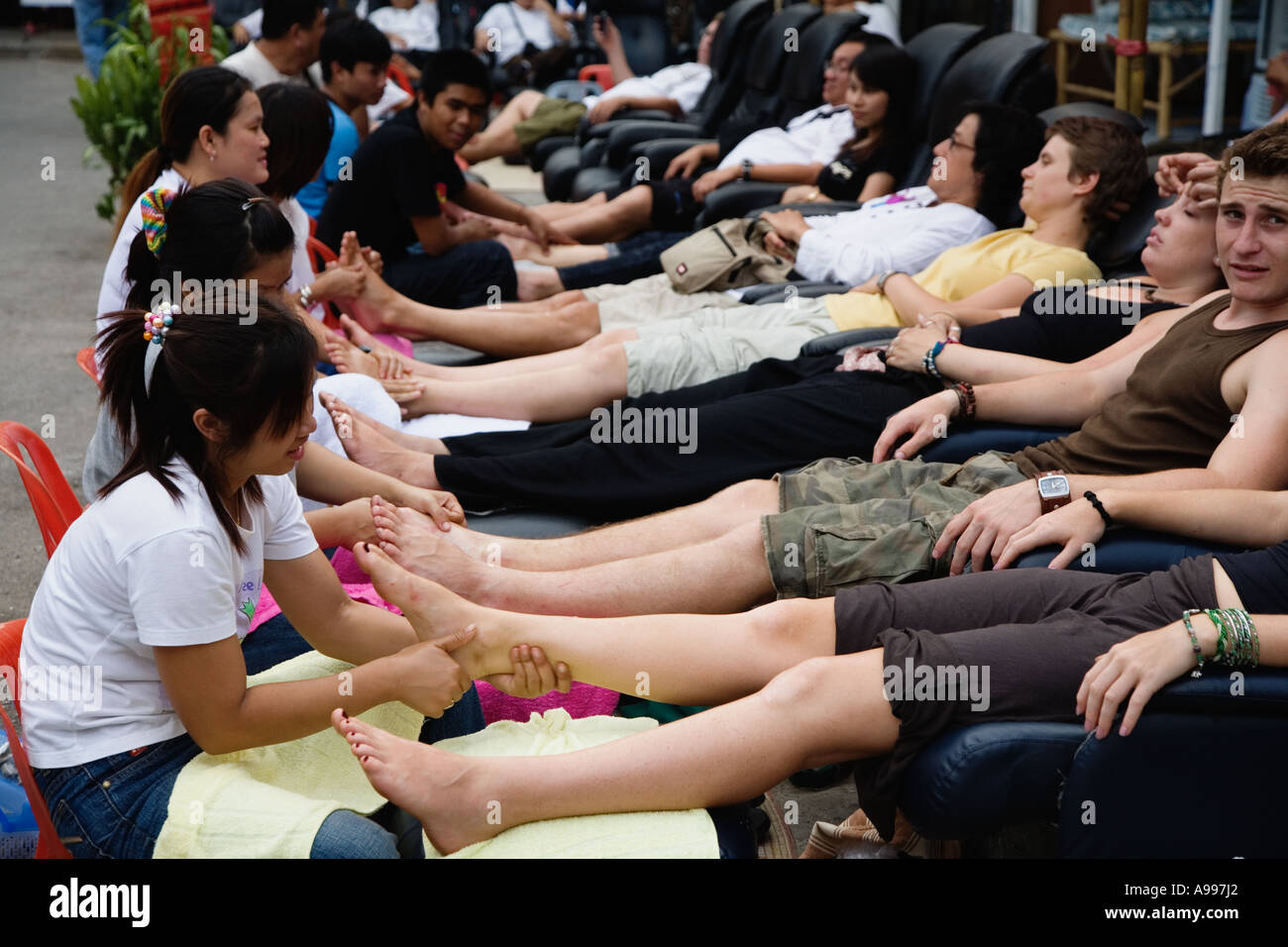 Los masajes de pies está dada en una plaza del mercado local en Chiang Mai,  Tailandia Tailandia es conocida por su industria de masaje y es c  Fotografía de stock - Alamy