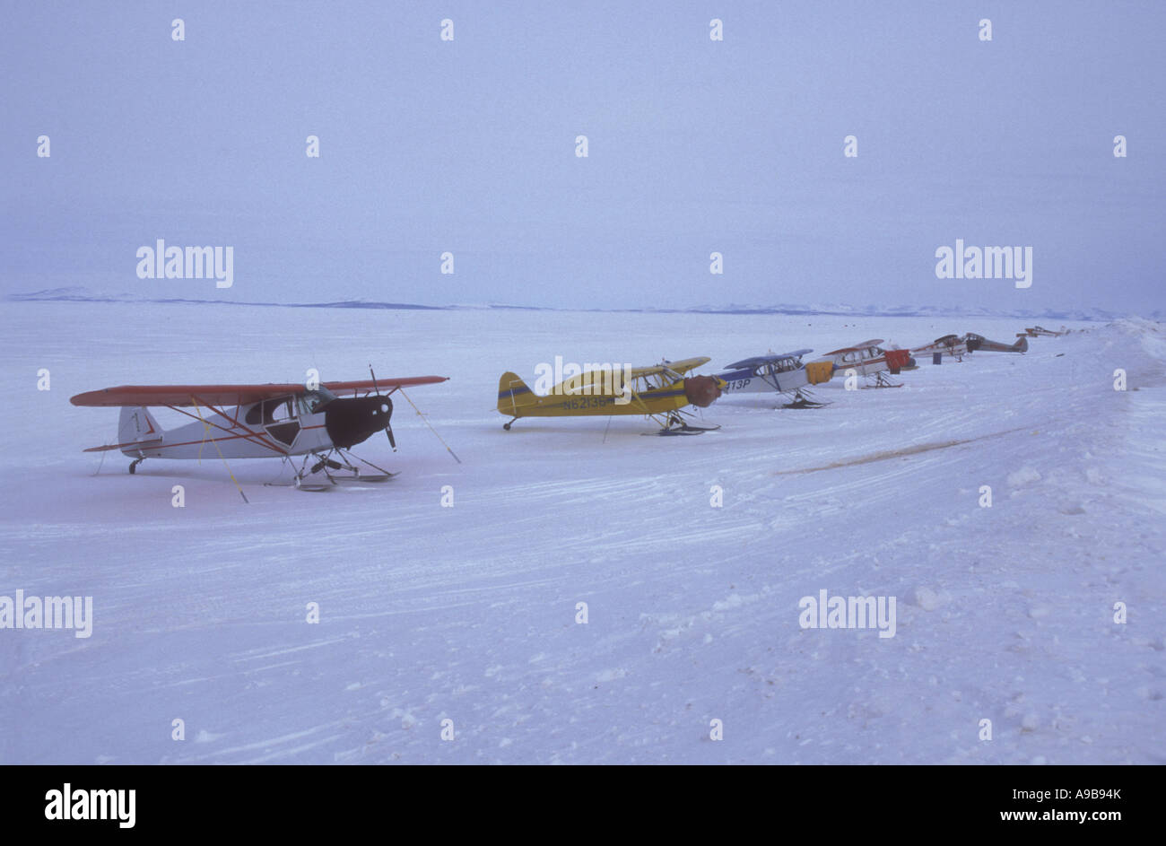 Pequeños aviones estacionados en packice en Kotzebue sound, en invierno, en el Noroeste de Alaska Foto de stock