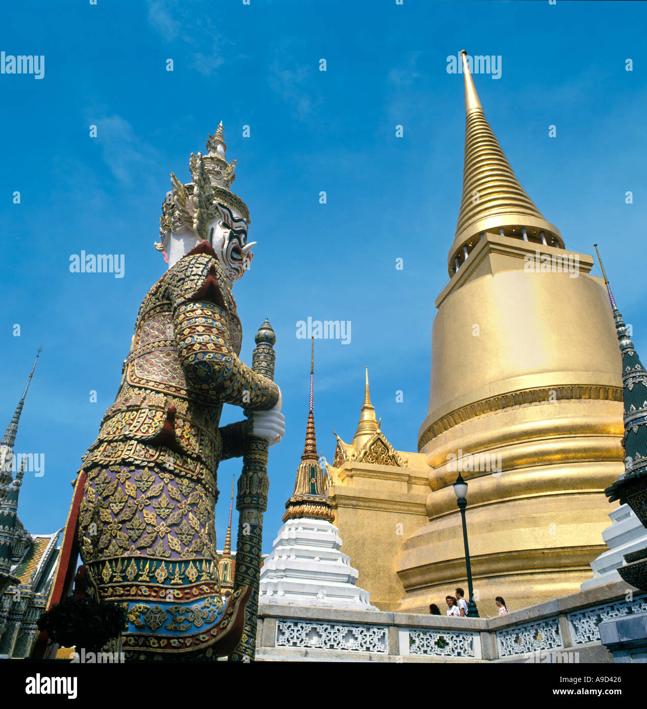 Estatua gigante en la terraza superior con el Phra Sri Ratana Chedi detrás, el Grand Palace, Bangkok, Tailandia Foto de stock