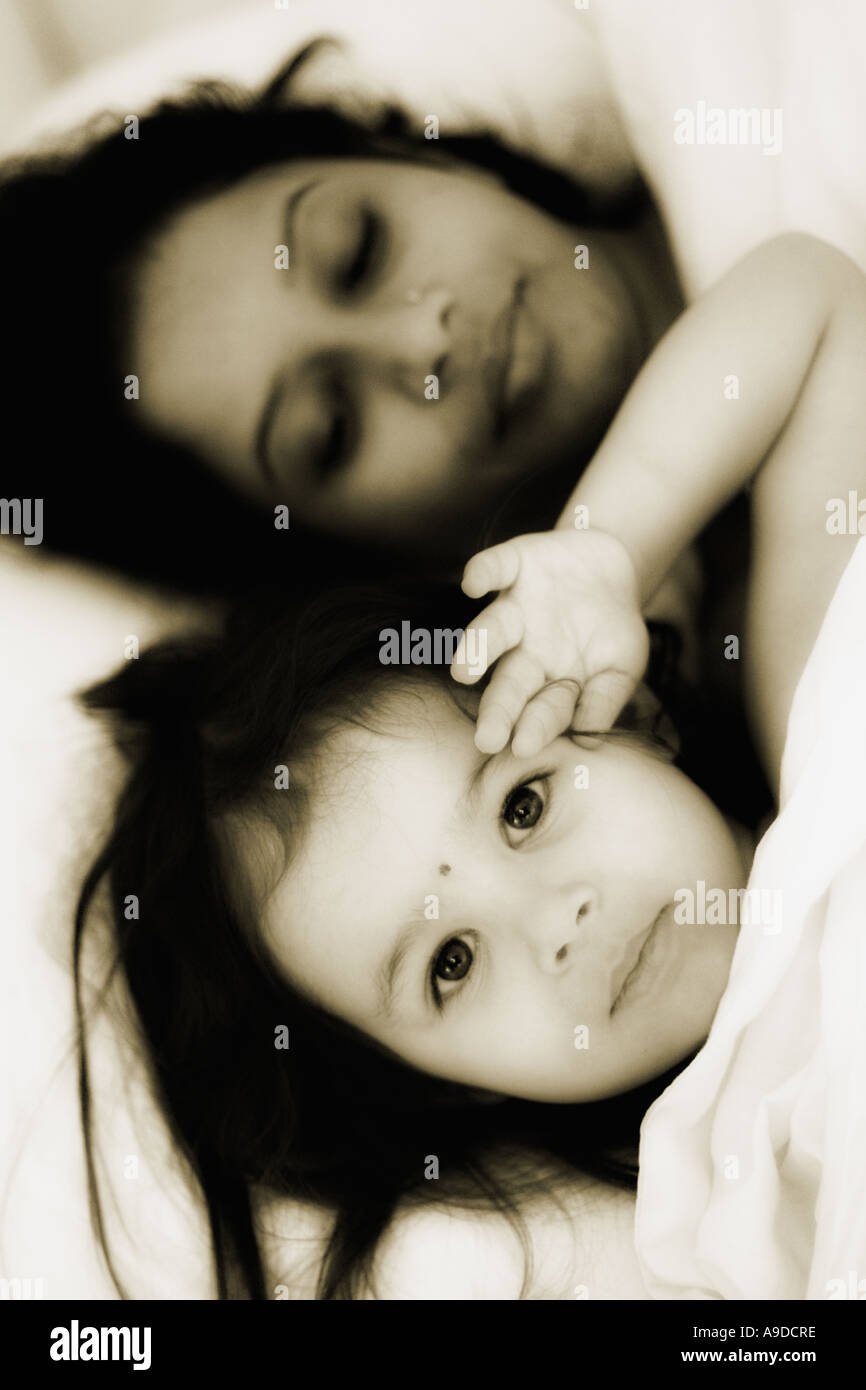 Madre e hija en la cama juntos Foto de stock