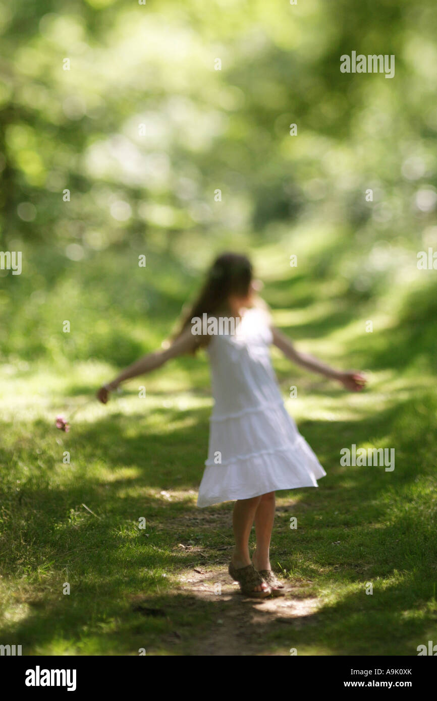 Una chica joven con el pelo largo en un vestido blanco Foto de stock
