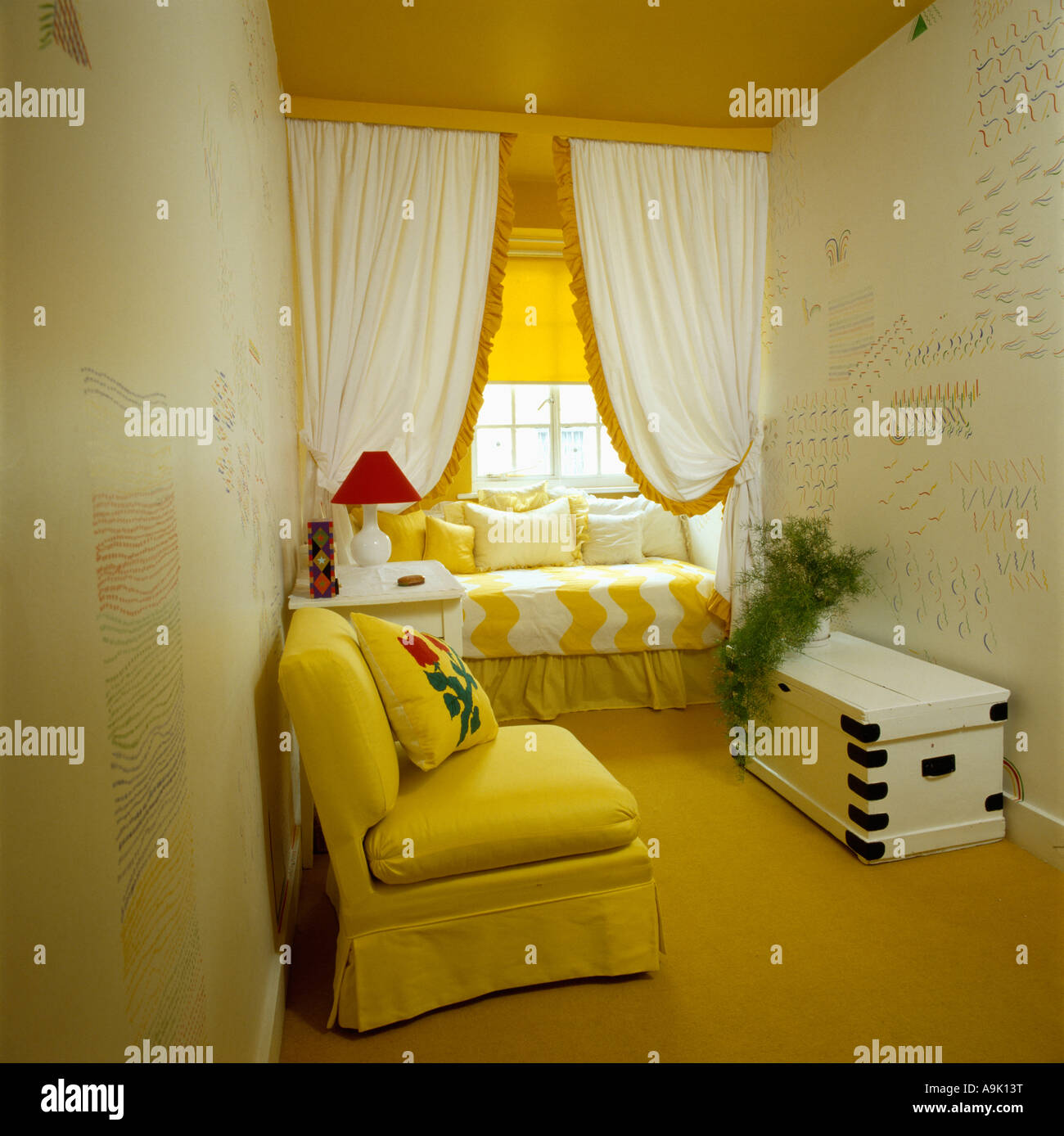 Sofá amarillo y alfombra con pintadas de blanco en el pecho pequeño 80  salón con cortinas blancas por encima del asiento de ventana Fotografía de  stock - Alamy