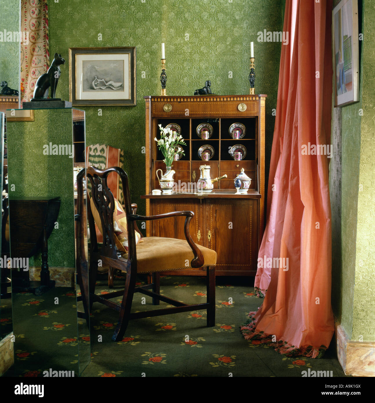 Silla y escritorio en la esquina de 80 Habitación con fondo verde y rojo  cortina de seda Fotografía de stock - Alamy