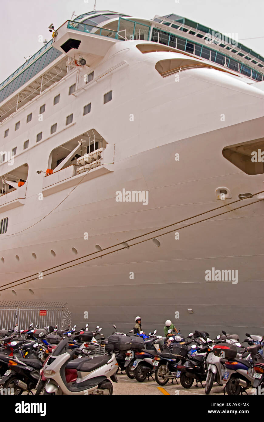 Bermudas Hamilton par rodeado por motos ciclomotores junto a crucero comparación en tamaño grande enorme vs pequeñas y Foto de stock