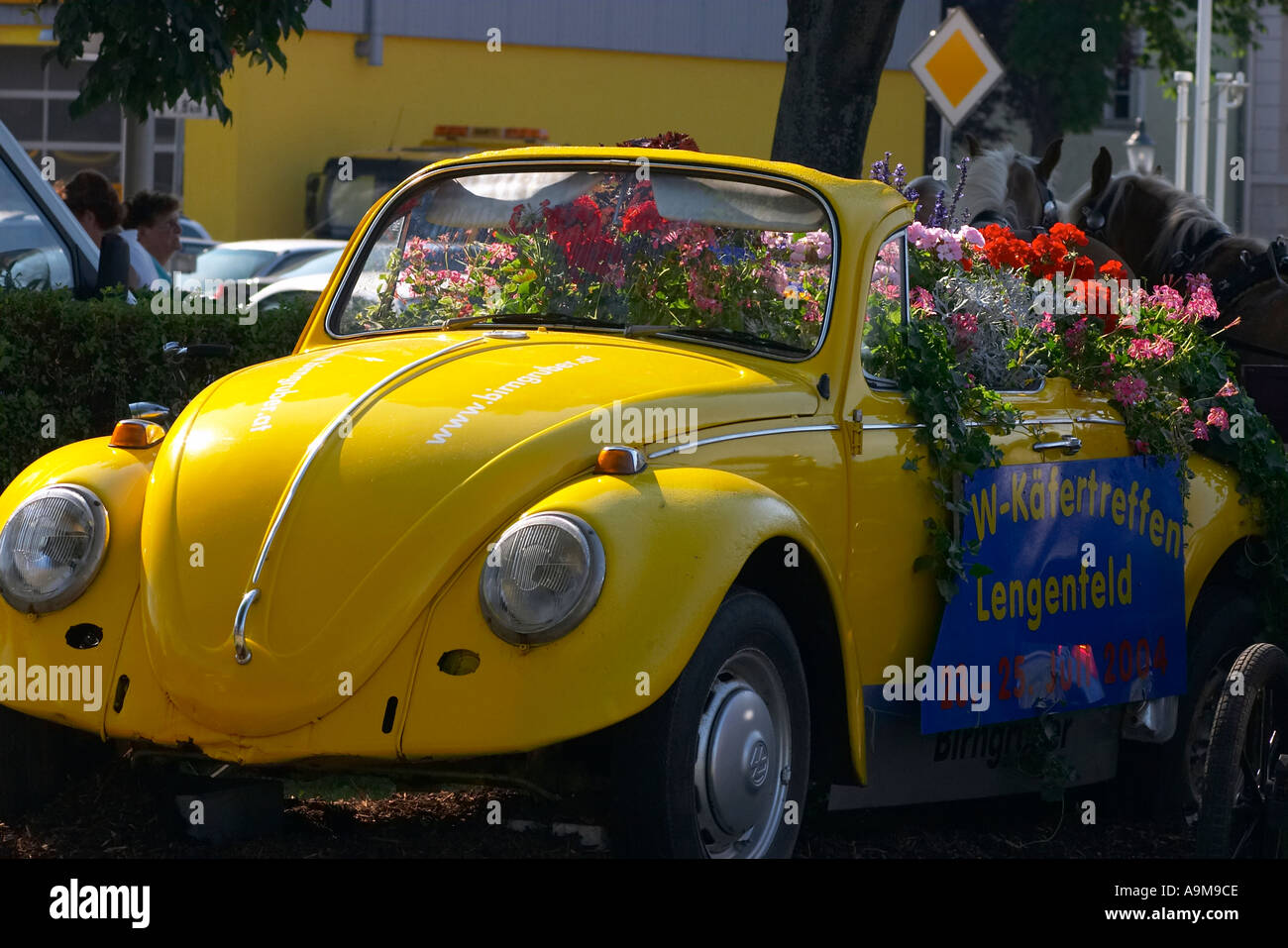 Amarillo Volkswagen Käfer decorado con flores. Foto de stock