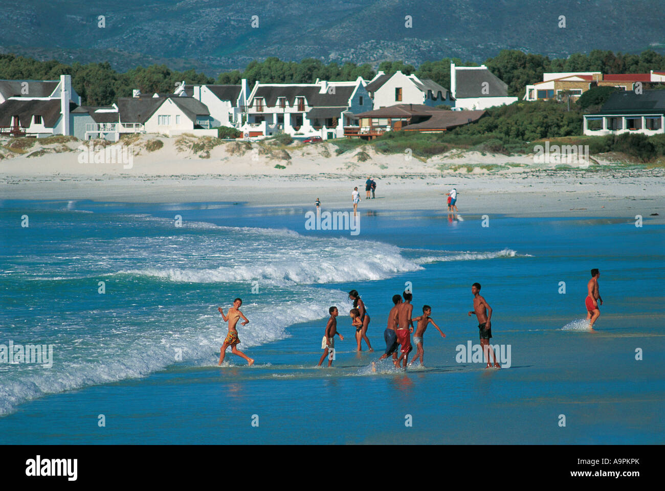 Las razas mixtas disfrutan de la diversión en la playa Kommetjie Cape Town South Africa Foto de stock