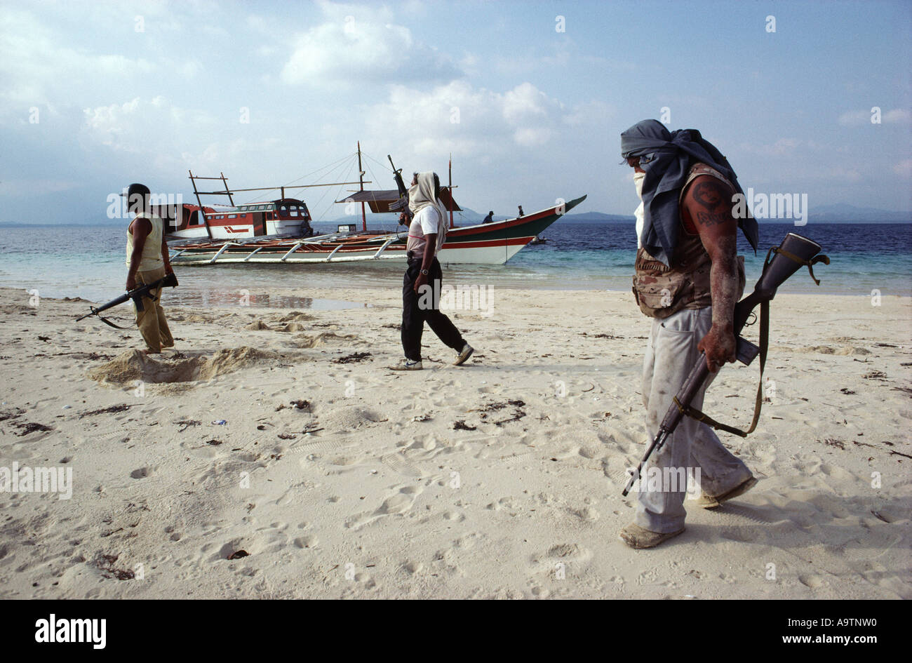 La tripulación de piratas caminando por la playa de arena, poco profundos, su barca en el fondo. Foto de stock
