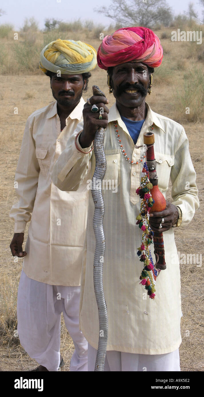 Rajasthán encantador de Serpientes con la serpiente en su mano y amigo mirando Foto de stock