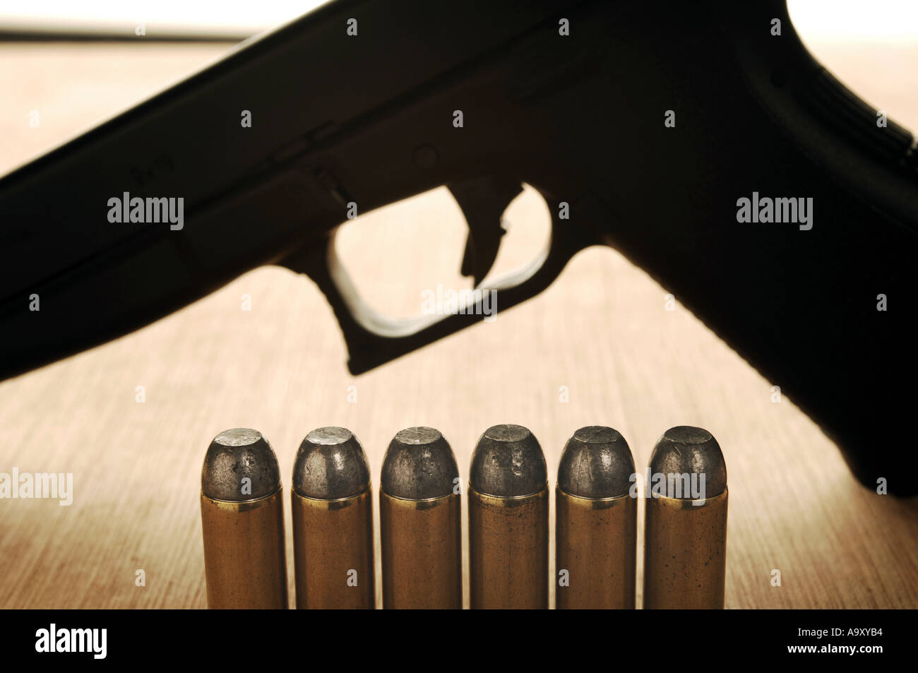 Una fila de balas de munición con un disparo de pistola Foto de stock