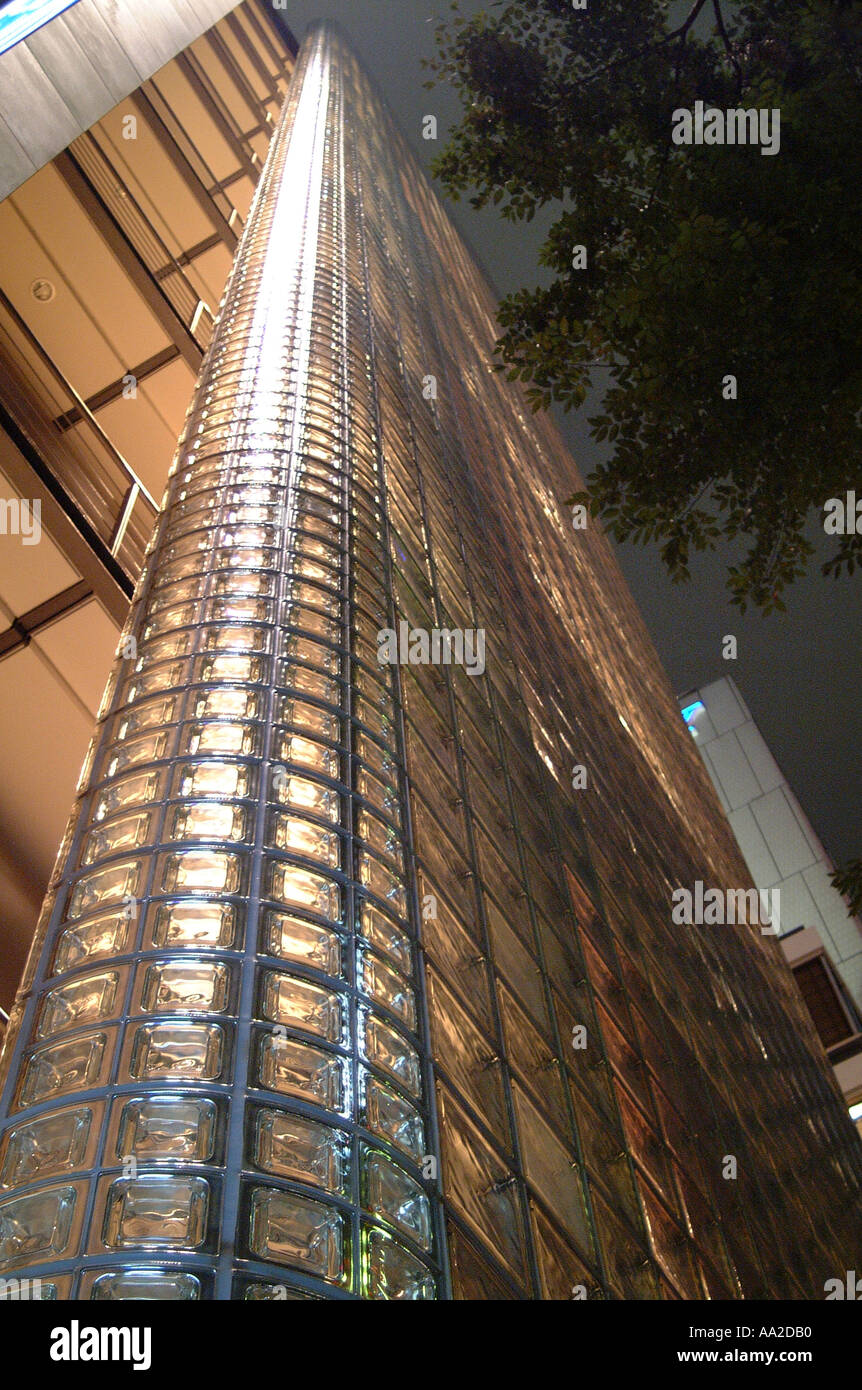 Edificio Hermes, vista nocturna, GiNew Zealanda, Tokio. Detalles de ladrillos de cristal mirando hacia arriba (verticles convergente). Foto de stock