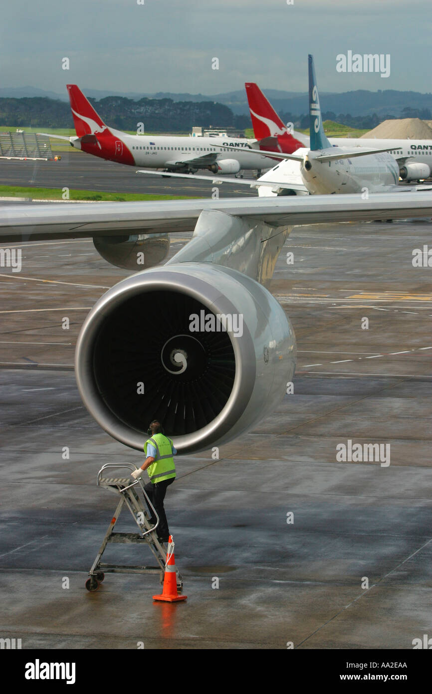 Un ingeniero de vuelo inspecciona el motor de un avión Boeing 747 en el aeropuerto internacional de Auckland Foto de stock