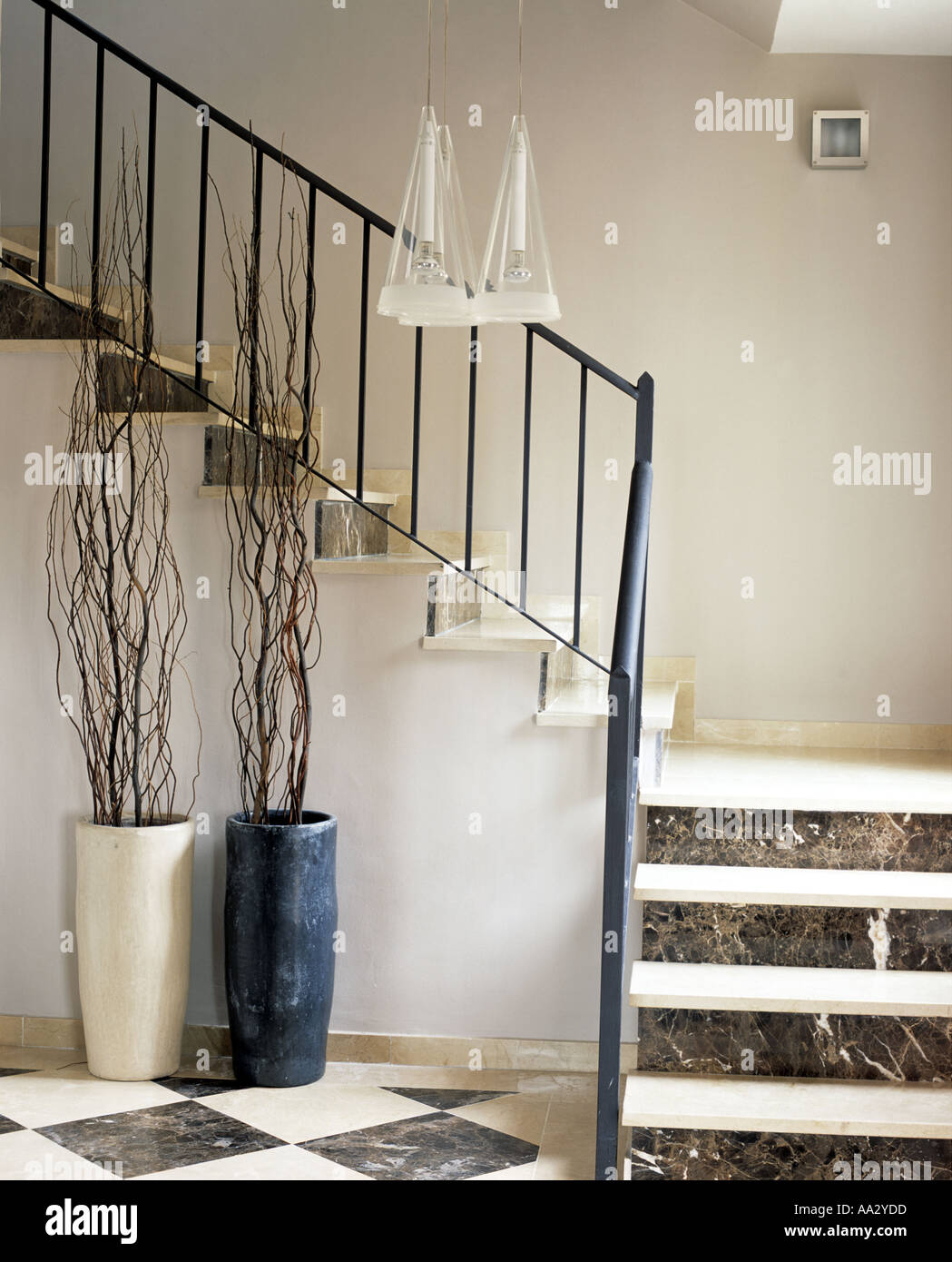 Sucursales en tall cerámica debajo de escalera con barandas metálicas y  escaleras de rodadura abierto en la moderna sala Fotografía de stock - Alamy