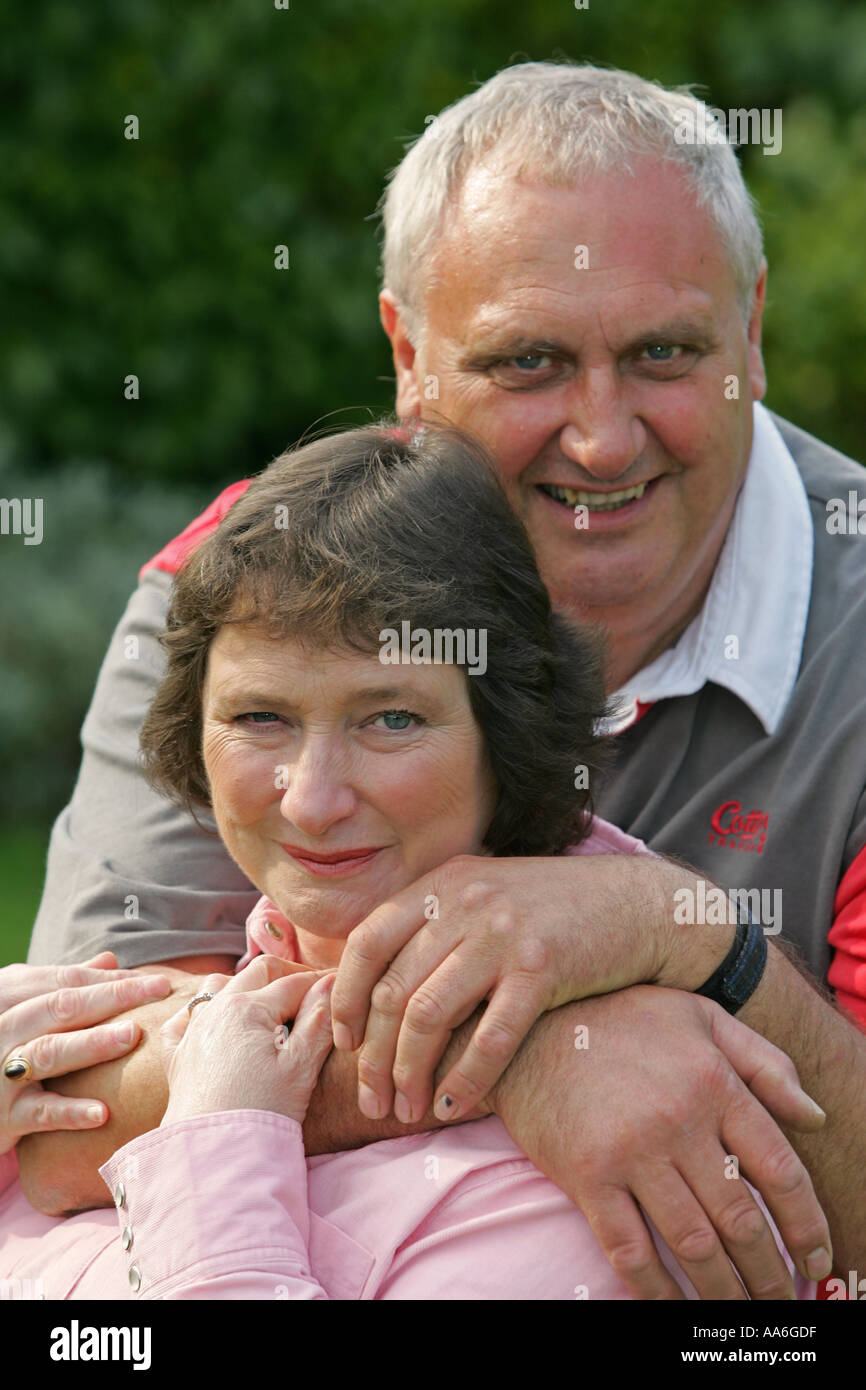 Inglés británico de mediana edad 50 s algo pareja casada grises en un romántico abrazo amoroso posan para la fotografía de retrato de familia Foto de stock