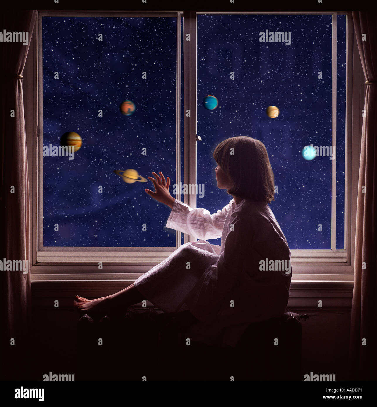 Chica busca mirando por la ventana a los planetas. Foto de stock