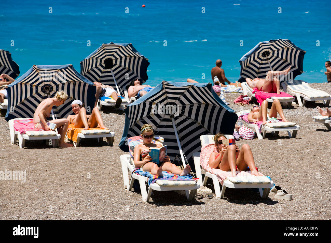Las personas tomando sol en las reposeras en la playa principal de la  ciudad de Rodas Rodas Fotografía de stock - Alamy