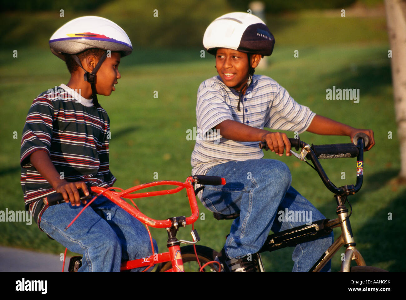 Los niños niño montando bicicleta bicicleta bicicleta bicicleta muchachos étnicos de 7-9 años de edad con casco cascos antiguos de la actividad exterior de los Estados Unidos ©Myrleen Pearson Foto de stock
