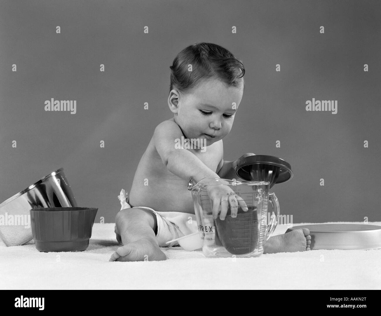 1950 en el pañal del bebé jugar con utensilios de cocina PYREX taza medidora LICUADORA CONCENTRACIÓN PAN POT VINTAGE Foto de stock