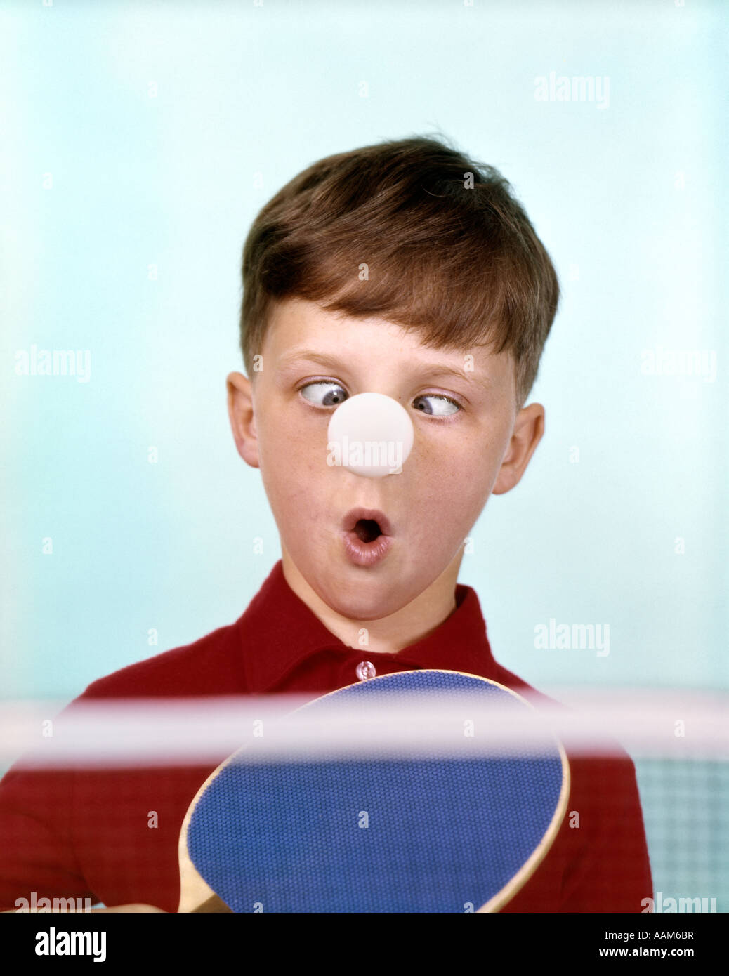 1970 1960 FUNNY CROSS-eyed BOY CAMISETA ROJA PING PONG Bola atascada en la  nariz HUMOR Fotografía de stock - Alamy