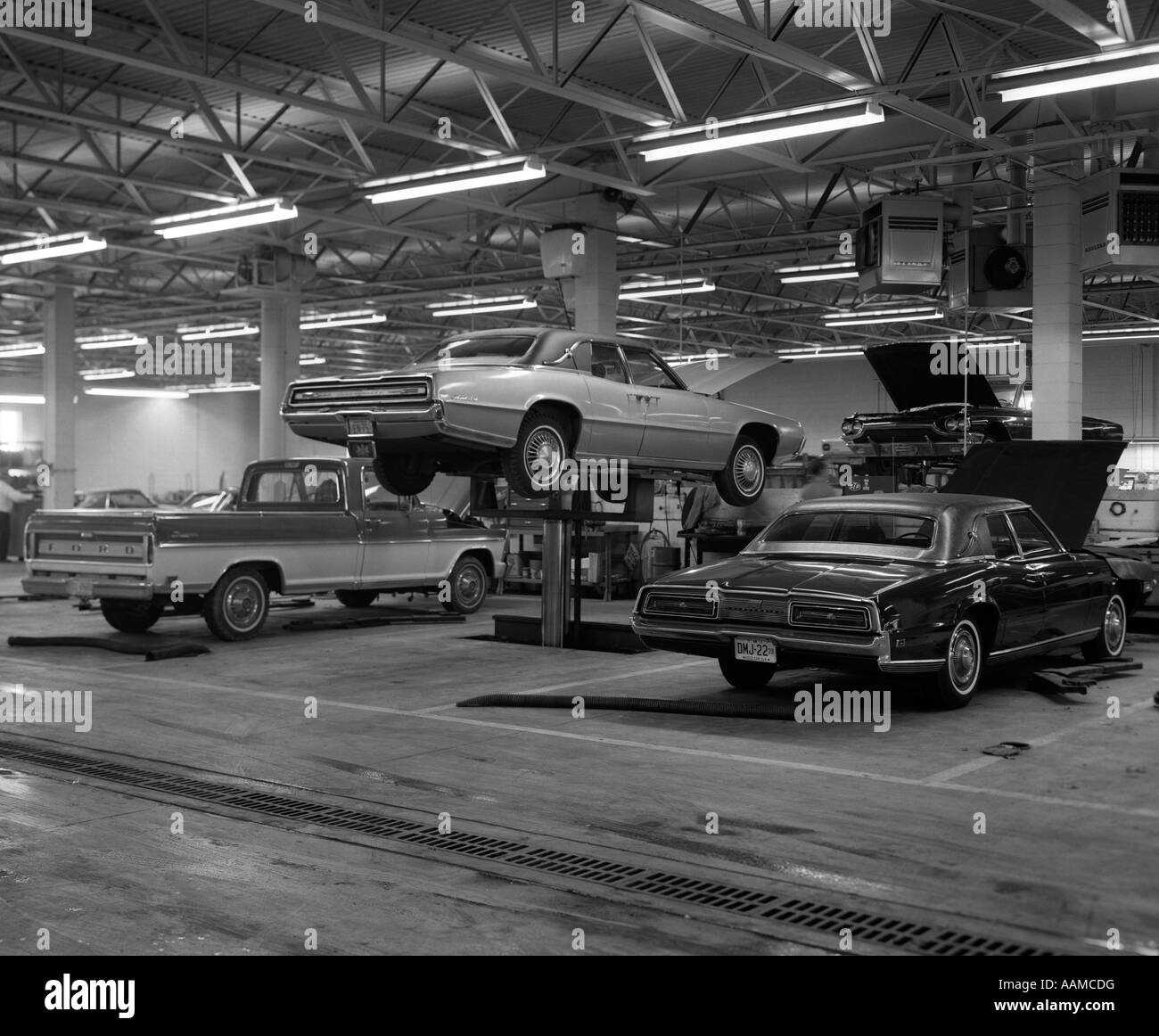 1960 Pickup y amplio garaje con 2 plazas de coche en Oriente es LEVANTADO POR EL ELEVADOR HIDRÁULICO Foto de stock