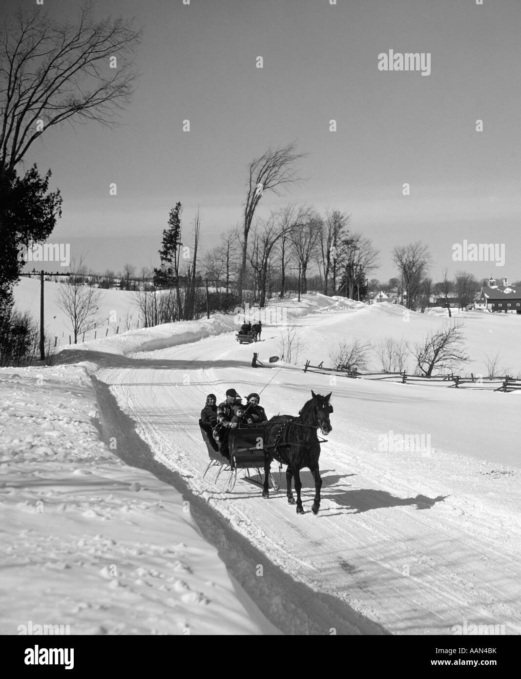 1960 Familia conduciendo por carreteras rurales en trineo abierto de un solo caballo Foto de stock