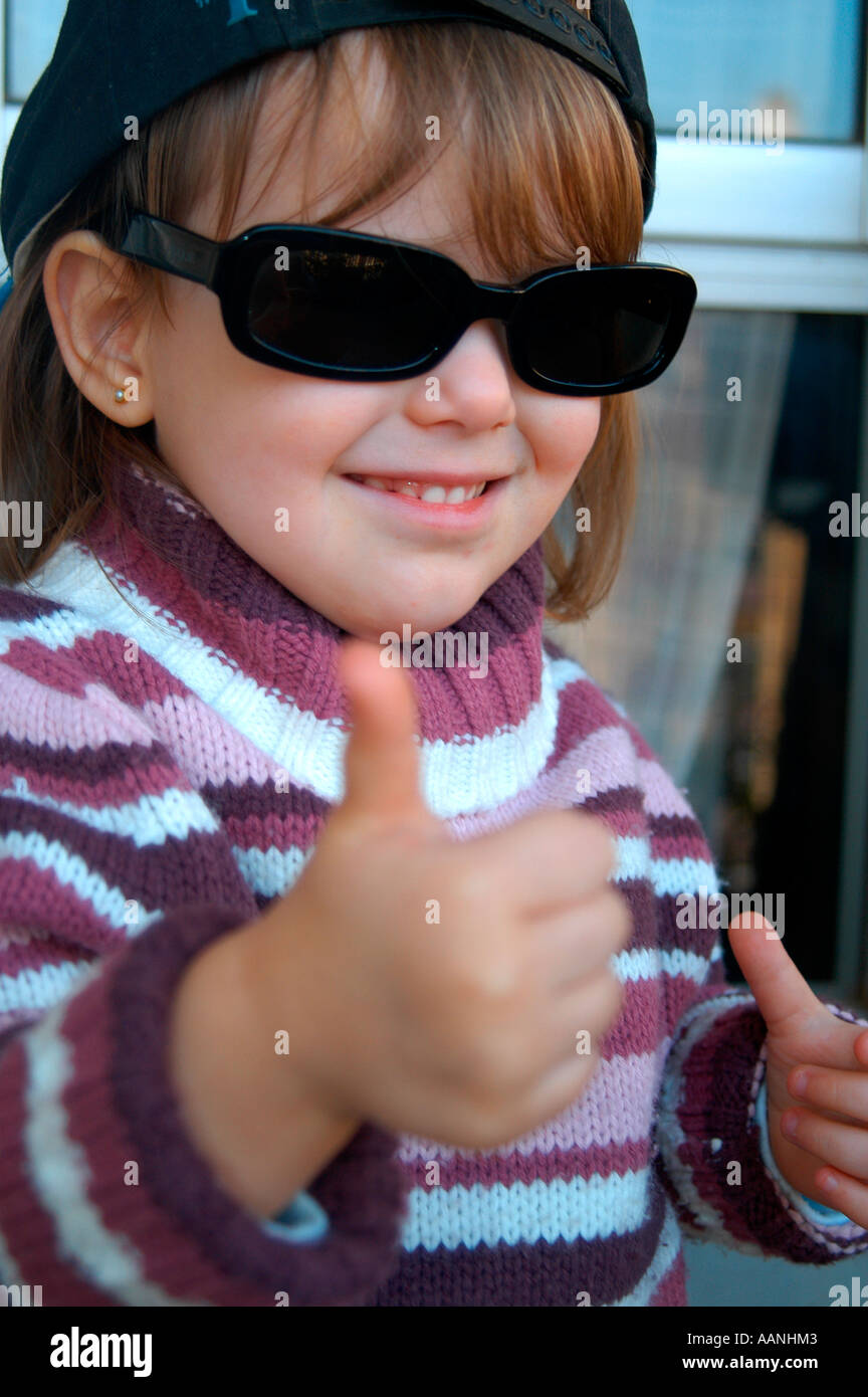Dulce niña de tres años con de sol y haciendo el signo de OK con la mano Fotografía stock - Alamy