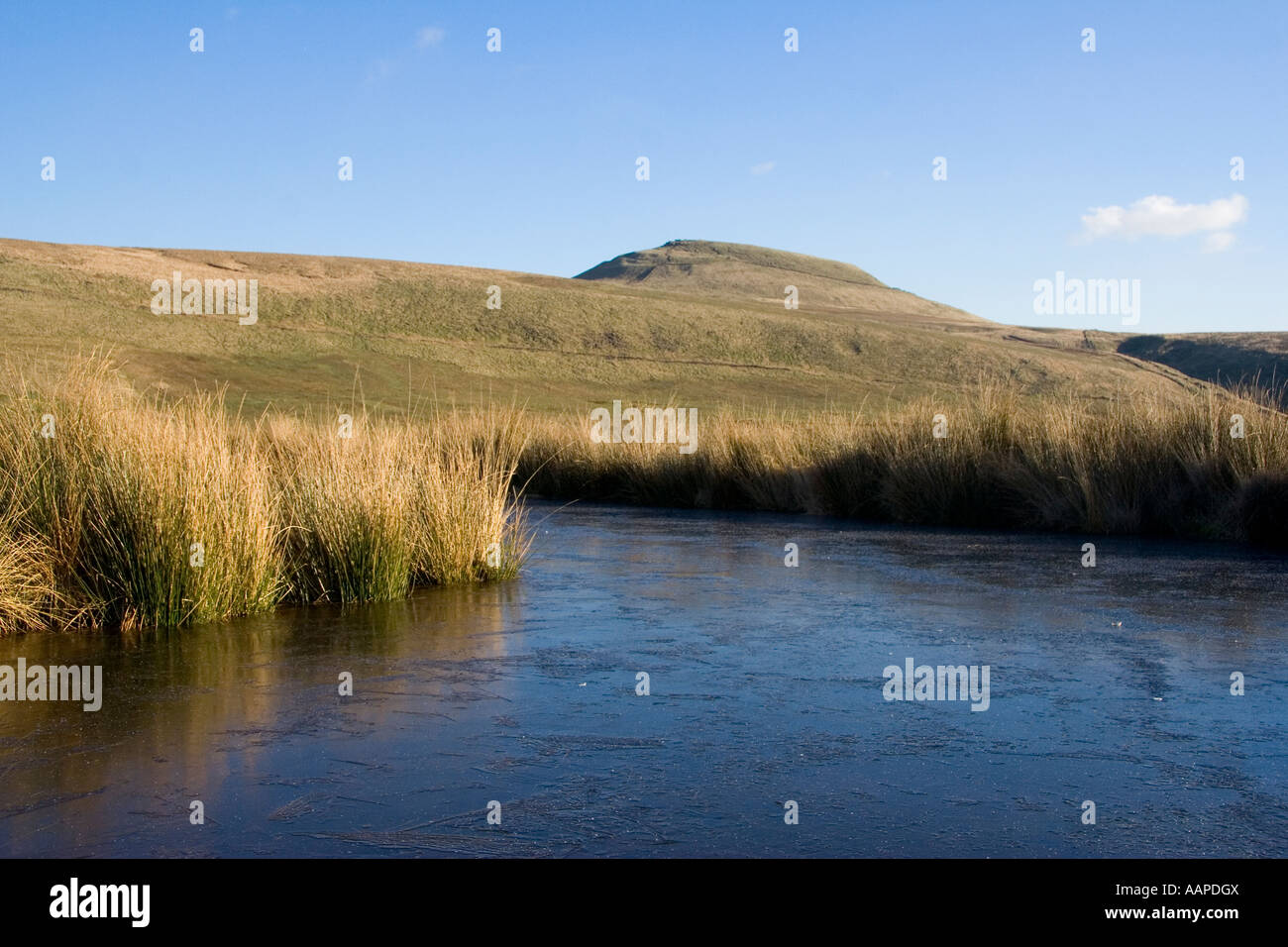 Vista hacia Shutlingsloe del Tarn en alto páramo helado Peak District Foto de stock